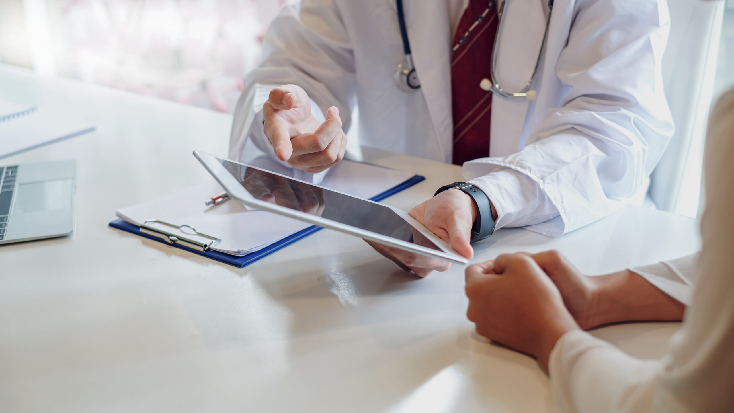 Doctor consultation with the patient by using digital tablet. Doctor uses a digital tablet and asks the patient's illness question.