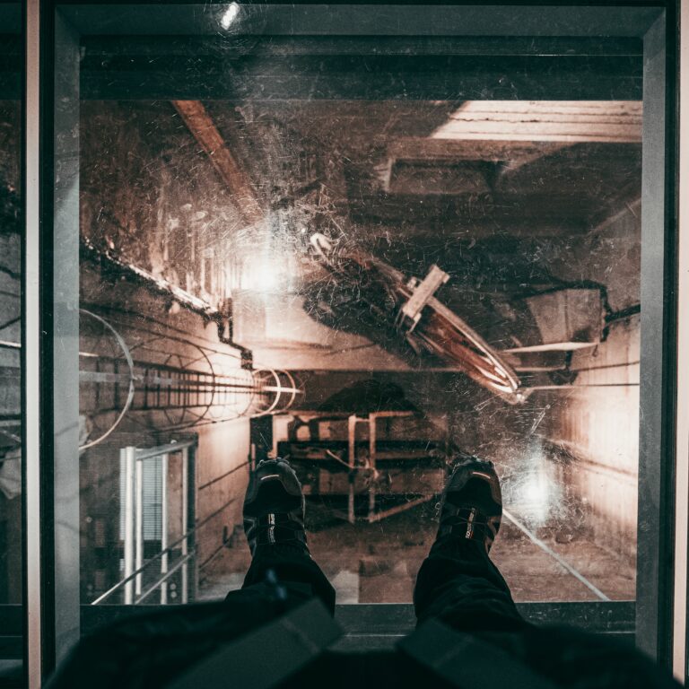 Feet on the glass floor of the elevator of an old building