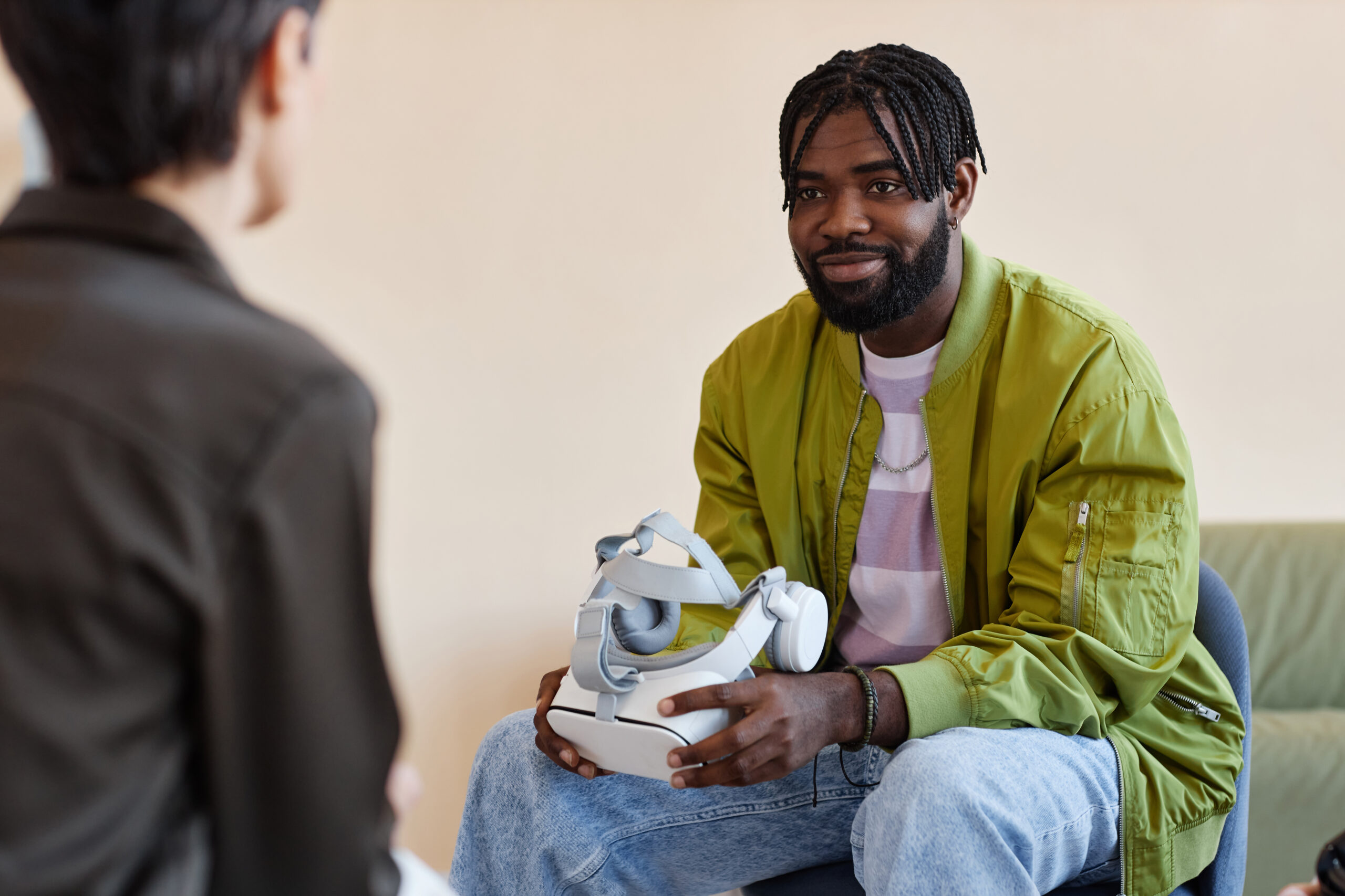 African American man testing VR glasses with psychologist during meeting in office