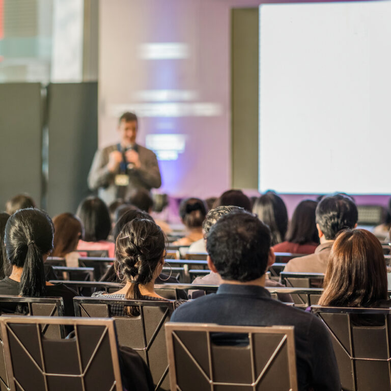 Rear view of Audience in the conference hall or seminar meeting which have speaker